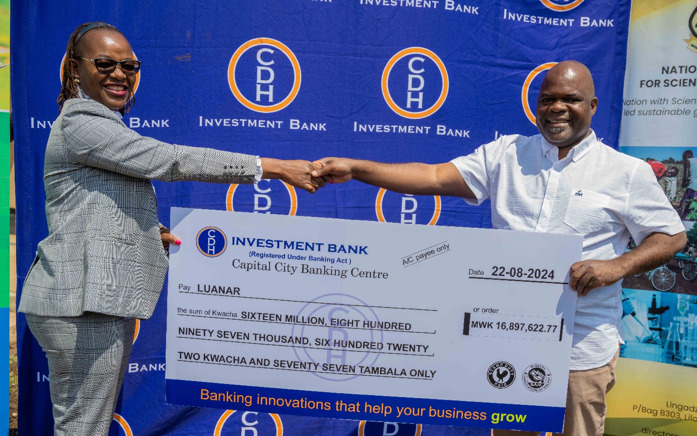 Mrs Jennie Madinga, CDH Investment Bank, Account Relationship Manager – Corporate and Public Sector, hands over a cheque to Dr Samson Katengeza, Director of Research and Outreach, at the Lilongwe University of Agriculture and Natural Resources