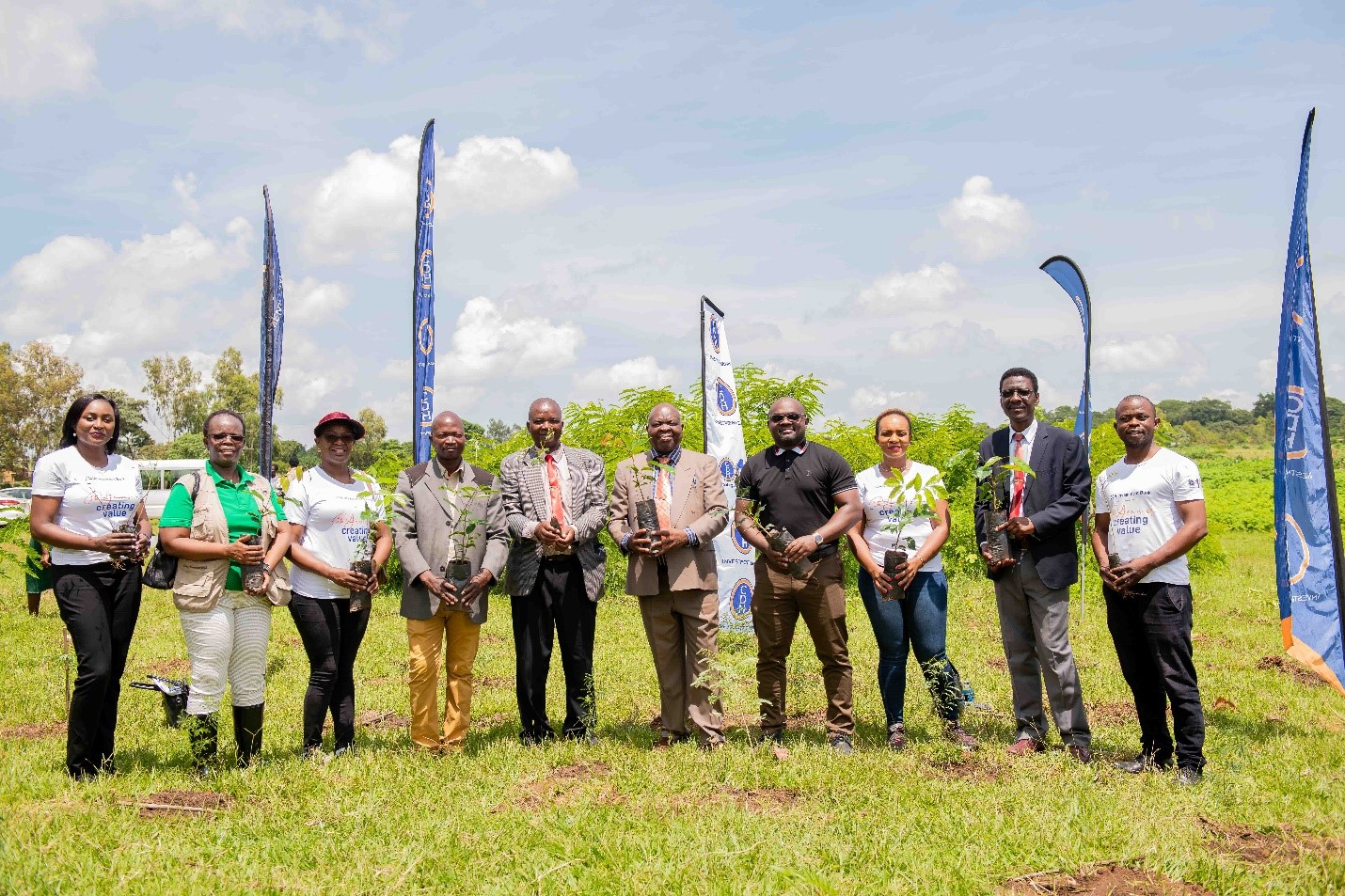 Representatives from CDH Investment Bank and Lilongwe University of Agriculture & Natural Resources pose with tree-seedlinga prior to commencing the tree-planting exercise