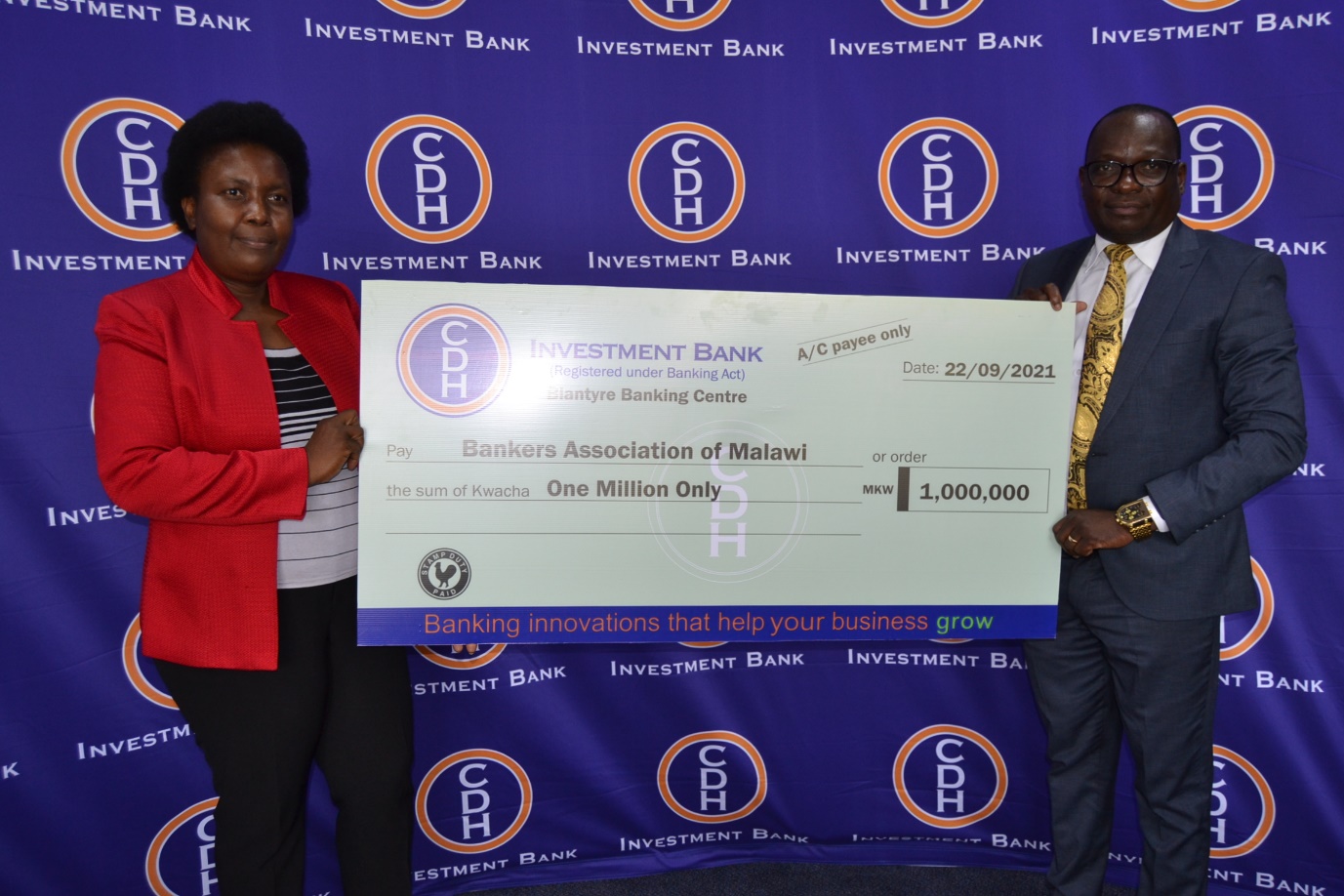 Mr Benison Jambo, Chief Business Development Officer of CDH Investment Bank hands over a cheque to Mrs Lyness Nkungula, Chief Executive Officer of the Bankers Association of Malawi