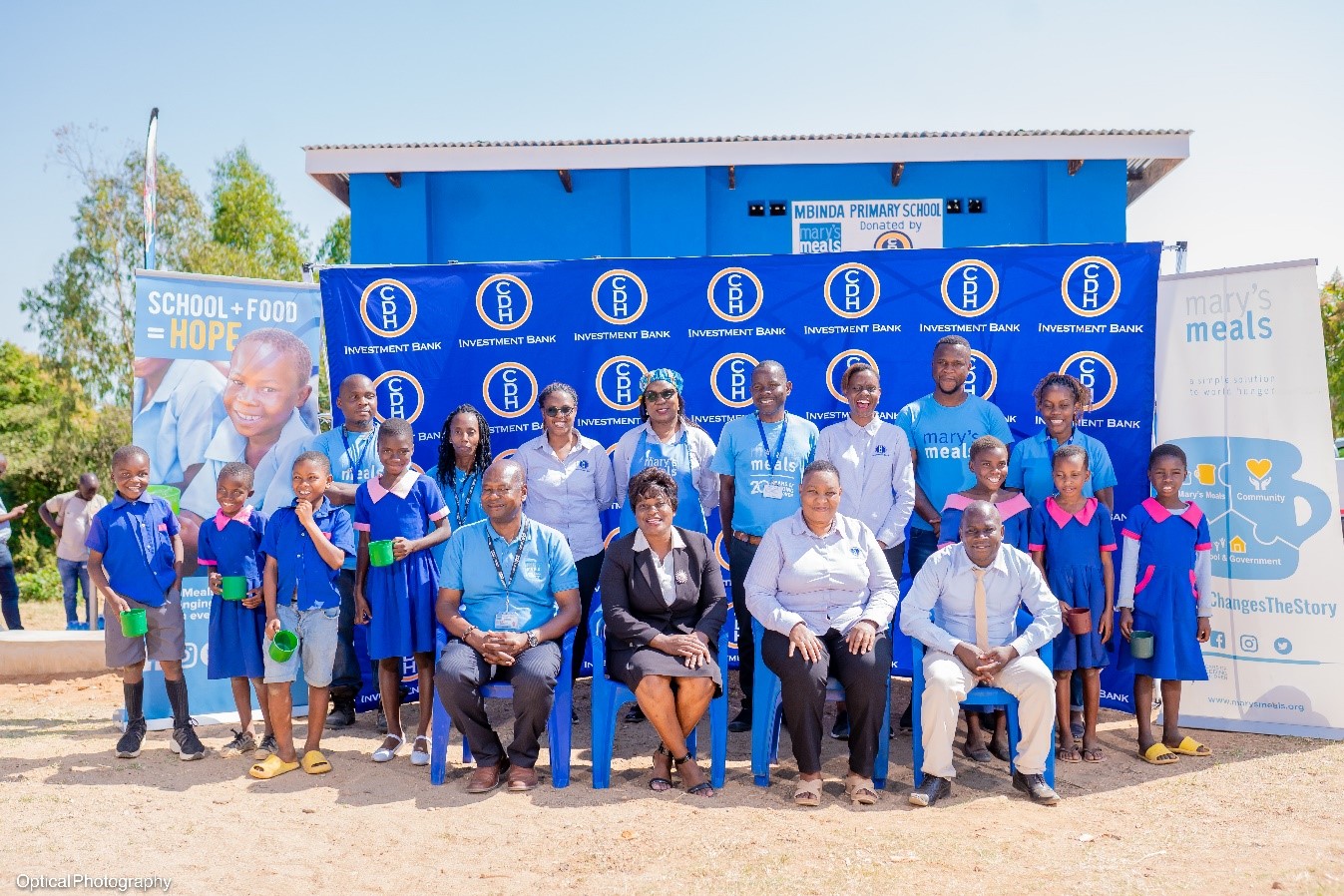 The head teacher and some learners from Mbinda Junior Primary School, some Mary’s Meals Malawi and CDH Investment Bank representatives pose with the Guest of Honor, Zelita Zamula, Ministry of Education Principal Education Officer in front of the new school kitchen and feeding block.